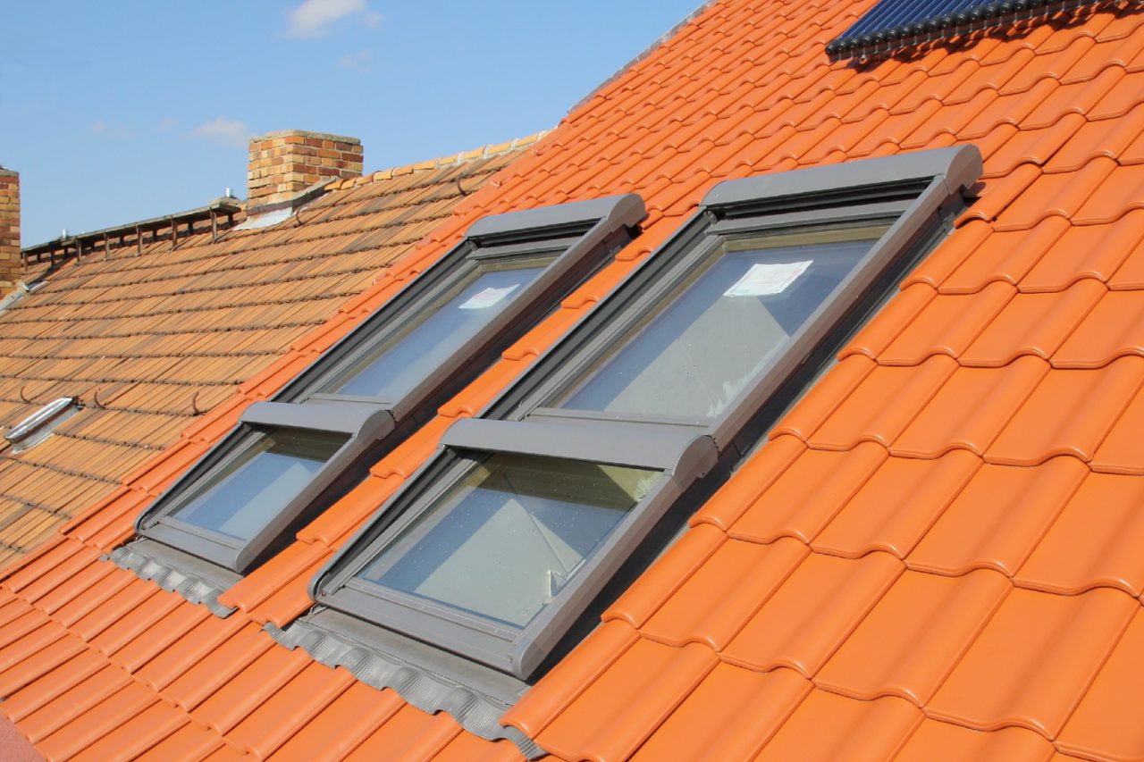 Große und energiesparende Dachflächenfenster - mit Sonnenschutzrollos. Oben die Solaranlage.